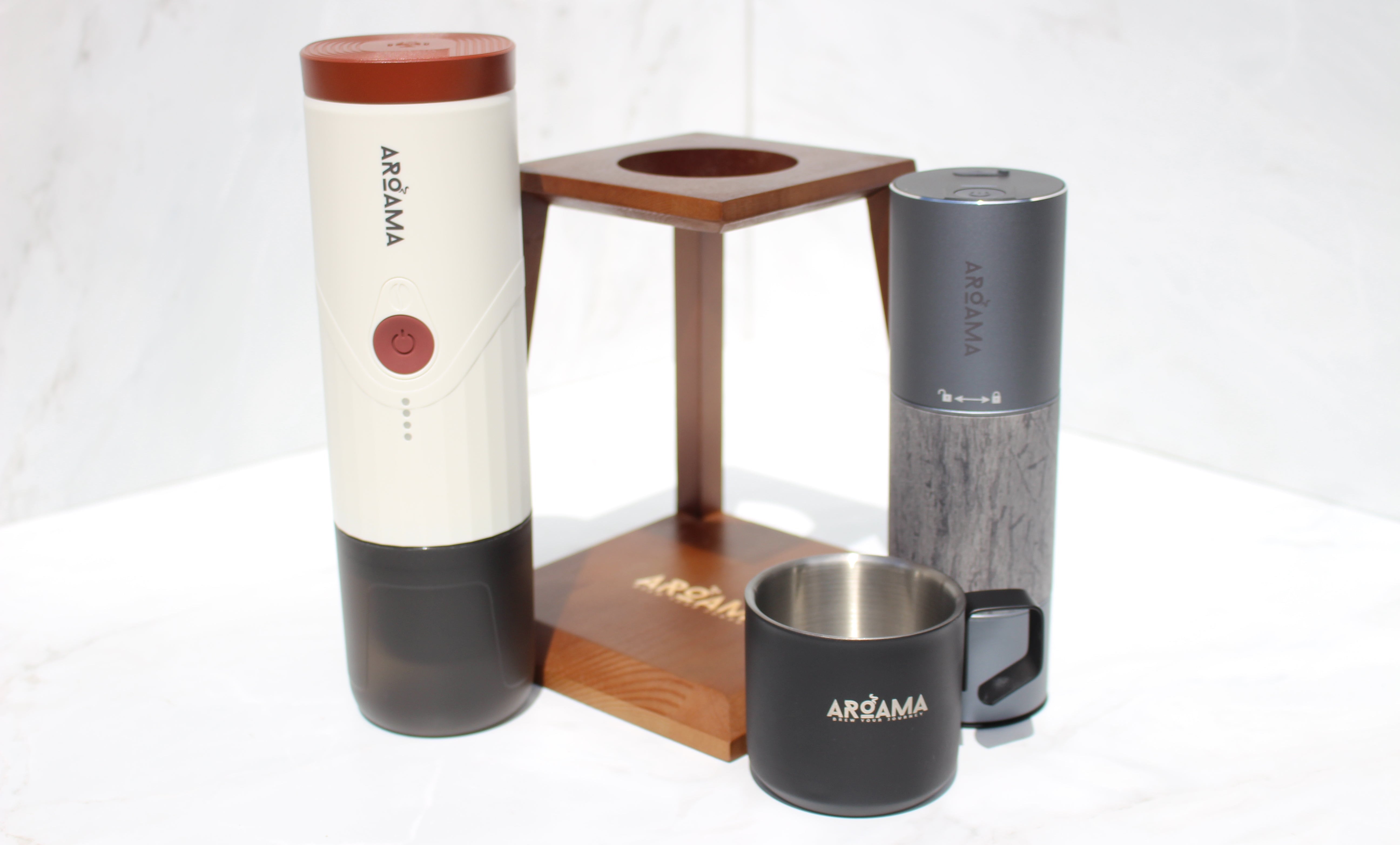 Set of Aroama products including a cylindrical container, wooden stand, and two cups on a white background